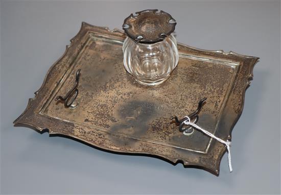 An Edwardian silver inkstand, with pen rest and single well, William Hutton & Sons, Ltd, Birmingham, 1906, 17.9cm.